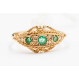 A Victorian style emerald and diamond 9ct gold ring, Etruscan design set with three round emeralds