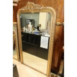 A large late 19th Century giltwood wall mirror, gesso moulded decoration to frame, scroll and
