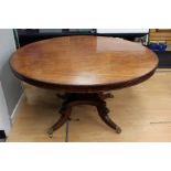 A mid Victorian mahogany breakfast table, the circular top with beaded edge, raised on a square