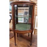 An Edwardian mahogany vitrine, curved form and fitted with a single door, shaped glass, 81cm high,