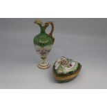 A Coalport porcelain box and cover, of shield form and painted with flower sprays within an