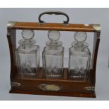 Oak tantalus with three cut-glass decanters  C R: No makers' mark on the tantalus, incorrect key