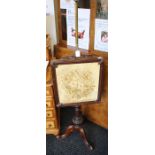 An early 19th Century mahogany pole screen, the square panel depicting a woolwork scene of a