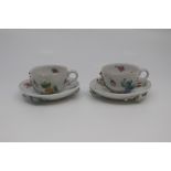 A pair of Dresden porcelain miniature teacups and saucers, late 19th Century, painted and applied