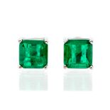 A pair of emerald and silver earrings, the emerald cut emeralds measuring approx. 7mm x depth