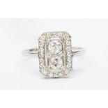 A diamond and platinum ring, rectangular shape set to the with two old cut diamonds with a