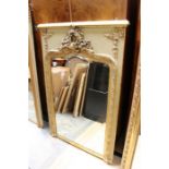 An early 20th Century giltwood framed wall mirror, gesso moulded top, Rococo moulded crest, bevelled