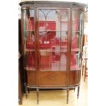 An Edwardian mahogany glazed display cabinet, fitted with a single door enclosing two shelves, curve