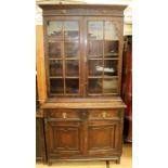 An early 20th Century oak bookcase, the upper section with blind fretwork cornice, comprising two