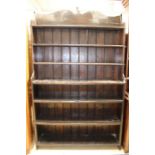 A late 19th / early 20th Century dark stained pine open bookcase, comprising seven fitted shelves
