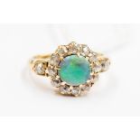 An early 20th Century 18ct gold set Opal and diamond cluster ring, the central stone 7mm across,