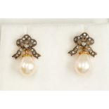 A pair of cultured pearl and diamond set earrings, bow tops set with small diamonds suspending pearl
