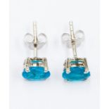 A pair of neon apatite and silver studs, comprising oval cut apatite approx. 6 x 4.5mm, claw