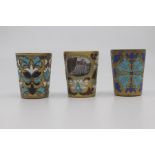 Three Russian gilt and enamelled vodka cups, of tapered form and decorated with stylised flowers and