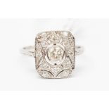 A diamond and platinum dress ring, the rectangular pierced mount set to the centre with a round