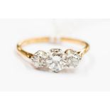 A three stone diamond and 18ct gold ring, comprising three round cut diamonds claw set, with a total