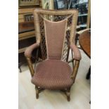 A mid 20th Century wicker armchair, with an upholstered panel to back and seat, with padded arms,