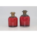 Two French gilt-metal mounted cranberry glass scent bottles, late 19th Century, the hinged covers