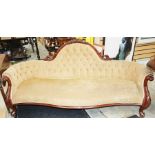 A Victorian mahogany settee, carved frame, deep buttoned back, sprung upholstered seat, raised on