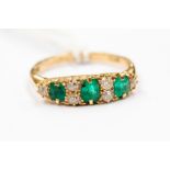 An emerald, diamond and 18ct gold ring, comprising three graduated oval emeralds with diamond