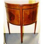 An Edwardian mahogany yew veneered demilune cabinet, fitted with two doors, having panels of amboyna