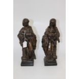 A pair of early 20th Century bronze figures depicting a scholarly lady and gent, ebonised bases,