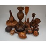 A collection of carved treen items mainly 20th Century comprising turned seed rattles, trinket