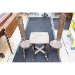 A pair of late 19th Century chip carved beech and elm seated back stools, raised on three legs,