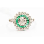 An emerald and diamond halo ring, set to the centre with an old cut diamond, approx 0.30ct, within a