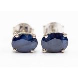 A pair of sapphire and silver studs, comprising oval cut sapphires approx. 7x 5mm, claw settings