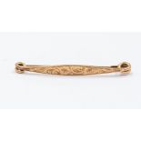 A 9ct gold ladies bar brooch, early 20th Century, engraved scrollwork decoration, C clasp,