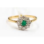 An 18ct gold set flower cluster ring with central emerald surrounded by eight brilliant diamonds