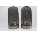 A pair of Continental pewter candle sconces, 20th Century, with arched backs and lobed trays