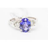 A tanzanite and diamond ring, comprising a central oval tanzanite, approx. 8.9 x 6.8mm, weight