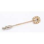 An Edwardian pearl set stick pin in the form of a horse shoe, 18ct and 9ct gold, total gross