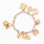 A 9ct gold charm bracelet with seven various charms including a bible, lighter,  and jug etc,
