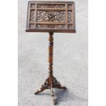 A Victorian style mahogany lecturn, having a carved and pierced sheet stand, raised on a turned