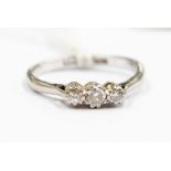 A diamond and platinum three stone ring, claw set round brilliant cut diamonds with a total