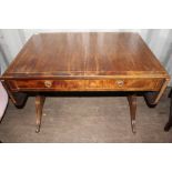 An early 19th Century mahogany sofa table, fitted with two drawers, raised on sabre legs