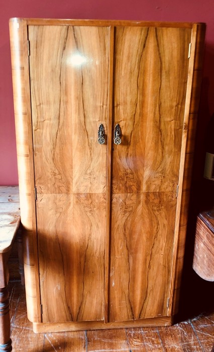 A 1960's walnut gentleman's wardrobe, two panel doors with brass handles opening to a chrome clothes