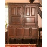 A Charles II oak livery cupboard, circa 1660, foliate carved cornice above two panelled doors on a