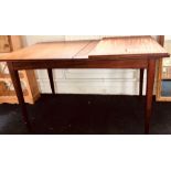 A 20th Century teak extending dining table, raised on tapered legs. 83 cm x 133 cm x 73 cm tall.