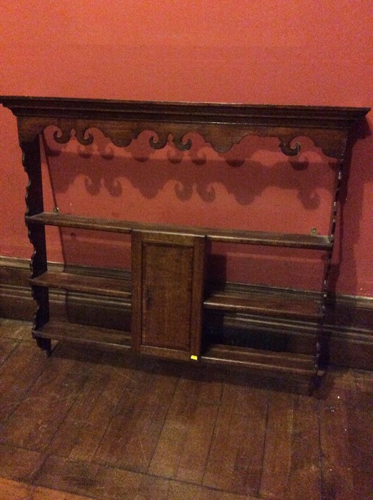 A 19th century oak carved wall hanging shelves, moulded cornice, three graduated shelves fitted with