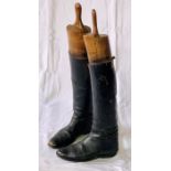 A pair of early 20th century leather Huntsman boots, with wooden boot spreaders.