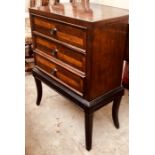 A 20th Century mahogany chest on stand, three drawers with turned metal handles, raised on tapered