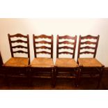 A set of eight late 18th Century elm and fruitwood rush seated chairs, ladder back, raised on