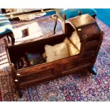 An early 18th Century oak cradle, circa 1710, squared tapered finials and panelled sides. 61cm H,