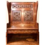 A George III boarded oak high-back settle, circa 1820, moulded panelled back with foliate carving,