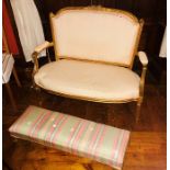 A 19th Century French giltwood two seater settee, cream upholstered seat and back, carved crest