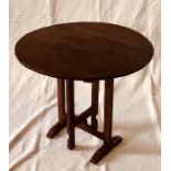 An early 19th century oak French design circular folding wine tasting table, the three plank top